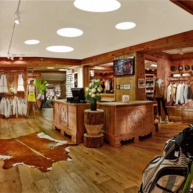 A modern sportswear store with wooden interiors. Various clothing items and accessories are neatly displayed.