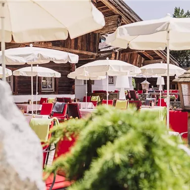 An inviting outdoor restaurant with colorful tables and umbrellas. The atmosphere is relaxed and friendly.