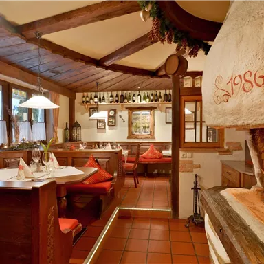 A cozy restaurant with a rustic fireplace and wooden furniture. The atmosphere is inviting and warm.