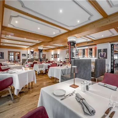 Ein elegantes Restaurant mit stilvollen Tischen und gemütlicher Beleuchtung. Die Einrichtung ist modern und einladend.