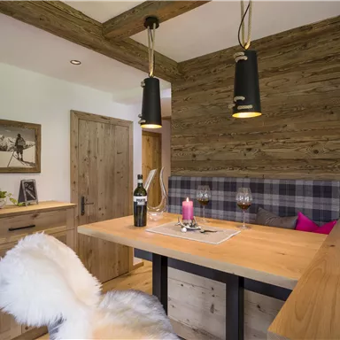 A cozy dining area with wood decor and a warm atmosphere. The table is elegantly set and the lighting creates a pleasant mood.