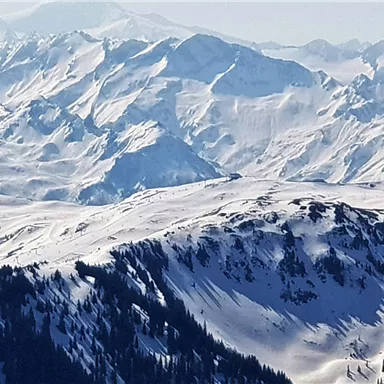 An impressive winter landscape with snow-covered mountains and clear sky. The majestic peaks rise high into the distance.
