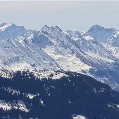 An impressive mountain landscape with snow-capped peaks. The sky is clear and the mountains appear majestic.