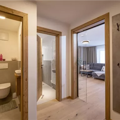 Ein modernes Apartment mit einem Badezimmer und einem Wohnbereich. Die Wände sind hell, und der Boden ist aus Holz.