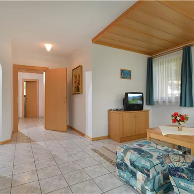 A cozy living area with a couch and a table. The rooms are bright, and friendly colors create an inviting atmosphere.