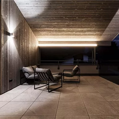 A modern terrace with stylish chairs and wooden paneling. The gentle lighting creates a cozy atmosphere at dusk.