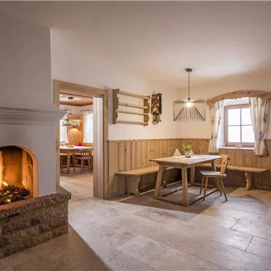 A cozy living space with an open fireplace. The room has wood paneling and an inviting atmosphere.