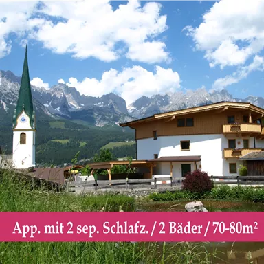 Eine schöne Landschaft mit einem Wohnhaus und einer Kirche im Vordergrund. Im Hintergrund sind majestätische Berge und strahlend blauer Himmel sichtbar.