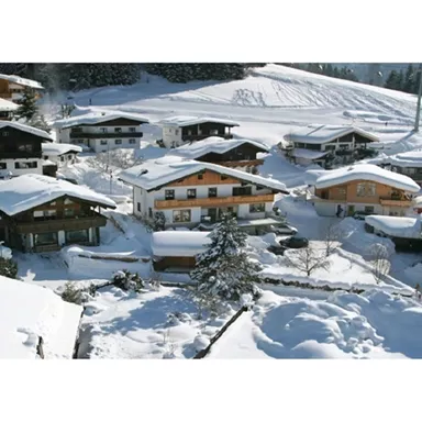 A picturesque village in the snow with traditional chalets and snowy landscapes. The houses are surrounded by a beautiful winter landscape.