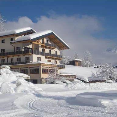 A picturesque building in a snowy mountain landscape. The sun shines on the freshly fallen snow.