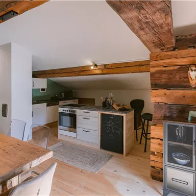 Moderne Küche mit Holzdetails und offener Gestaltung. Der Essbereich ist gemütlich und einladend.