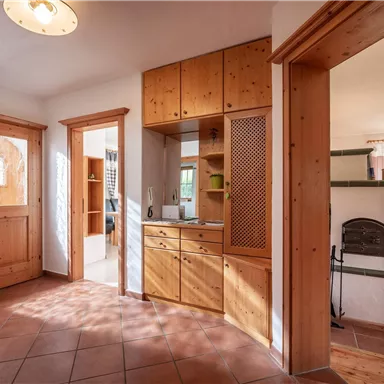 Ein einladender Eingangsbereich mit hellen Holzschränken und einem schönen Fliesenboden. Das große Fenster sorgt für viel Tageslicht und eine freundliche Atmosphäre.