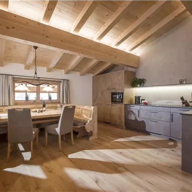A modern and cozy dining room with wooden furniture. Large windows let in plenty of light and create an inviting atmosphere.