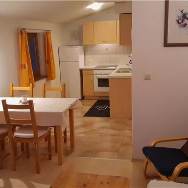 A bright kitchen unit with a dining table and chairs. The room is designed to be cozy and inviting.