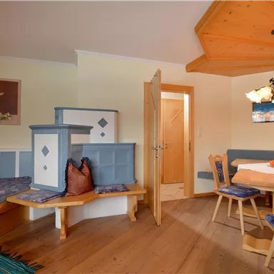 Ein gemütliches Zimmer mit modernem Holzdekor. Es gibt eine Sitzecke und einen Esstisch, ideal für entspannte Abende.