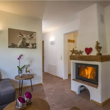 A cozy living space with a fireplace and a modern sofa. The atmosphere is inviting and warm, perfect for relaxing evenings.