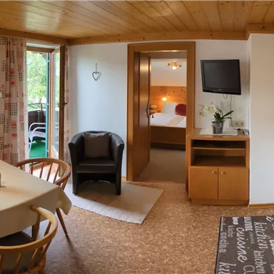 Eine gemütliche Wohnung mit einer Essecke und einer modernen Kücheneinheit. Die Räume sind hell und einladend, mit Blick auf die Außenlandschaft.