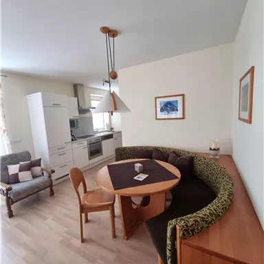 Eine helle und moderne Küche mit einem Essbereich. Der runde Tisch ist von einer gemütlichen Sitzbank umgeben.