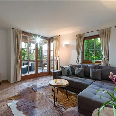 A cozy living room with a gray sofa and a small table.
Large windows let in plenty of light and offer a view of the balcony.