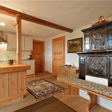 A cozy kitchen with wooden details and a traditional oven. The room exudes a warm and inviting atmosphere.