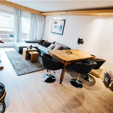 A modern and cozy living room with a comfortable sofa and a dining table.
Large windows let in plenty of light and offer a nice view outside.