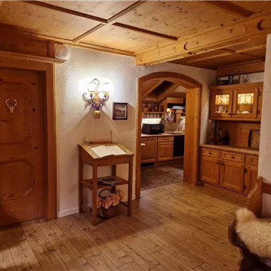 Ein gemütlicher Eingangsbereich mit Holzdekor und warmem Licht. Die Gegenstände im Raum schaffen eine einladende Atmosphäre.