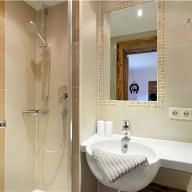 Ein modernes Badezimmer mit Dusche und Waschbecken. Weiche Farben und eine aufgefrischte Atmosphäre.