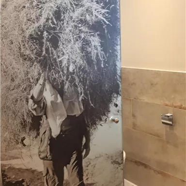 A black-and-white photo shows a person carrying a large pile of branches. The background is designed to be modern and bright.
