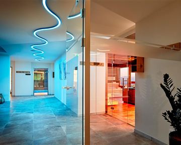 Ein moderner Innenraum mit glattem Steinboden und minimalistischem Design. Sanfte LED-Beleuchtung schafft eine einladende Atmosphäre.