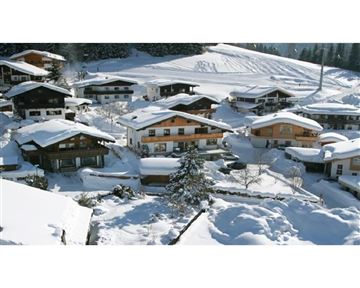 Ein malerisches Dorf im Schnee mit traditionellen Chalets und verschneiten Landschaften. Die Häuser sind von einer schönen Winterlandschaft umgeben.